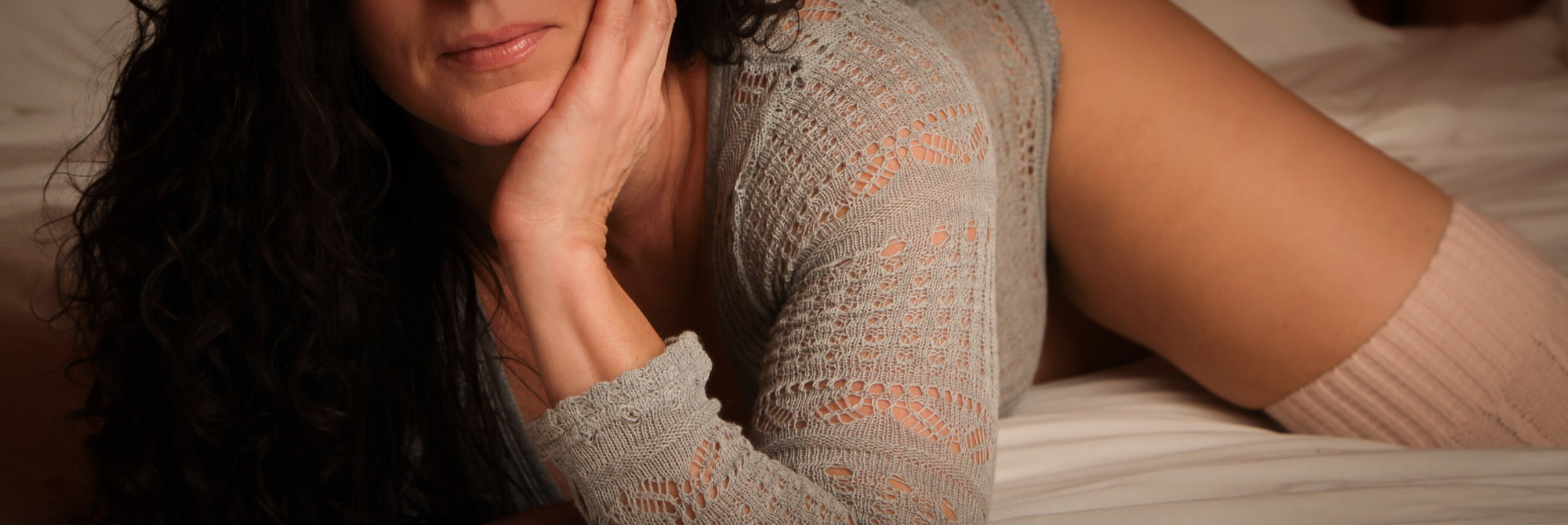 Boudoir photography portrait of a woman in a knit top and thigh-high socks, captured in soft light to convey intimacy and comfort, Lexington KY